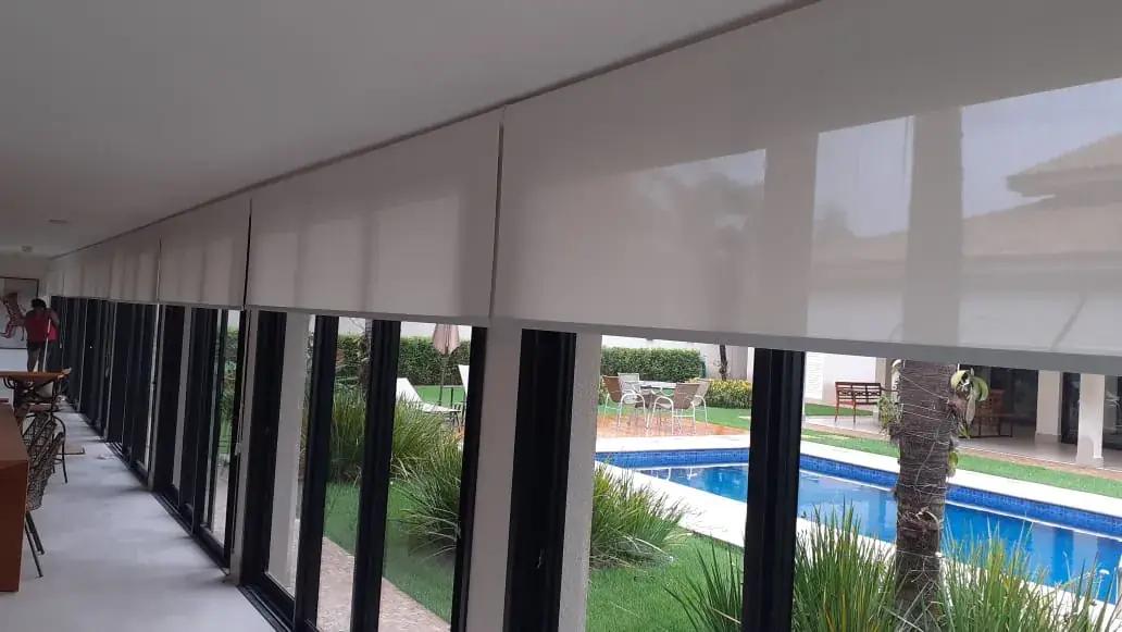 Cortinas rolô em janelas voltadas para a piscina em Araçatuba