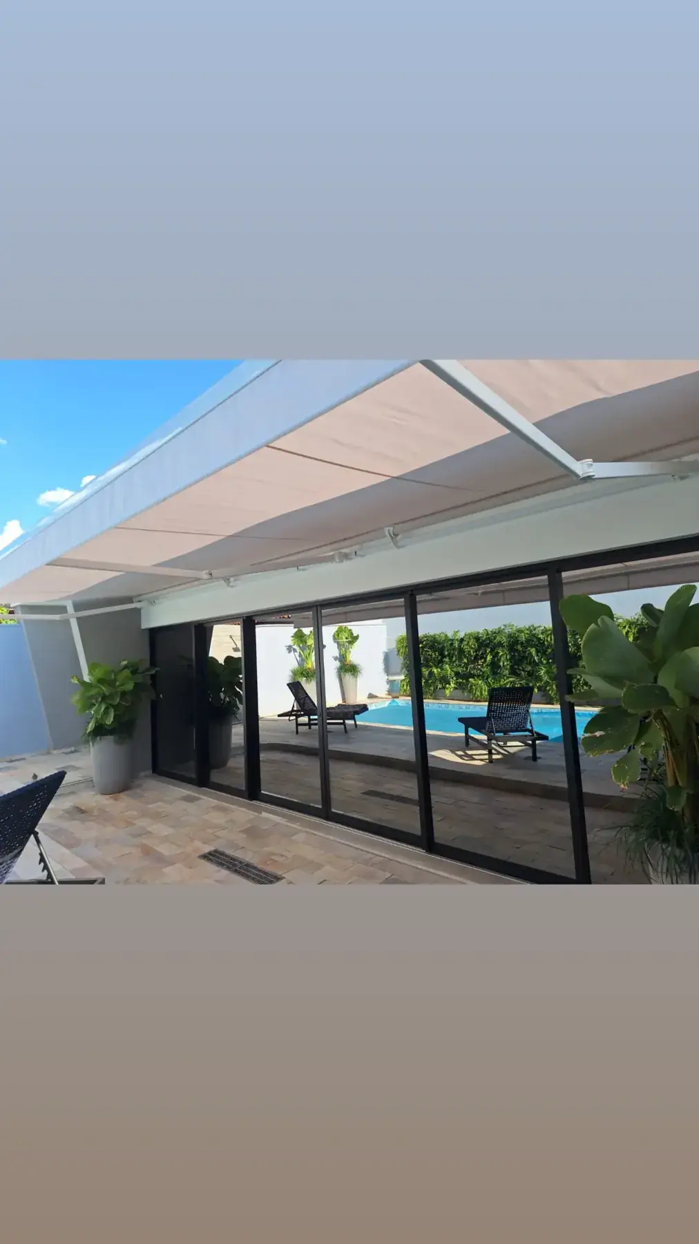 Toldo articulado branco sobre área de piscina