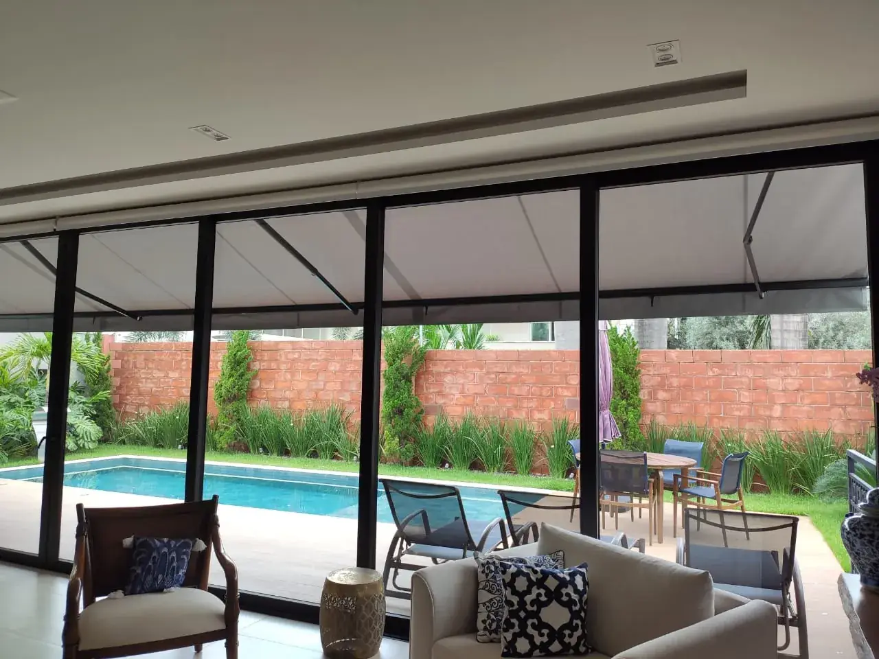Toldo articulado sobre varanda com piscina em Araçatuba